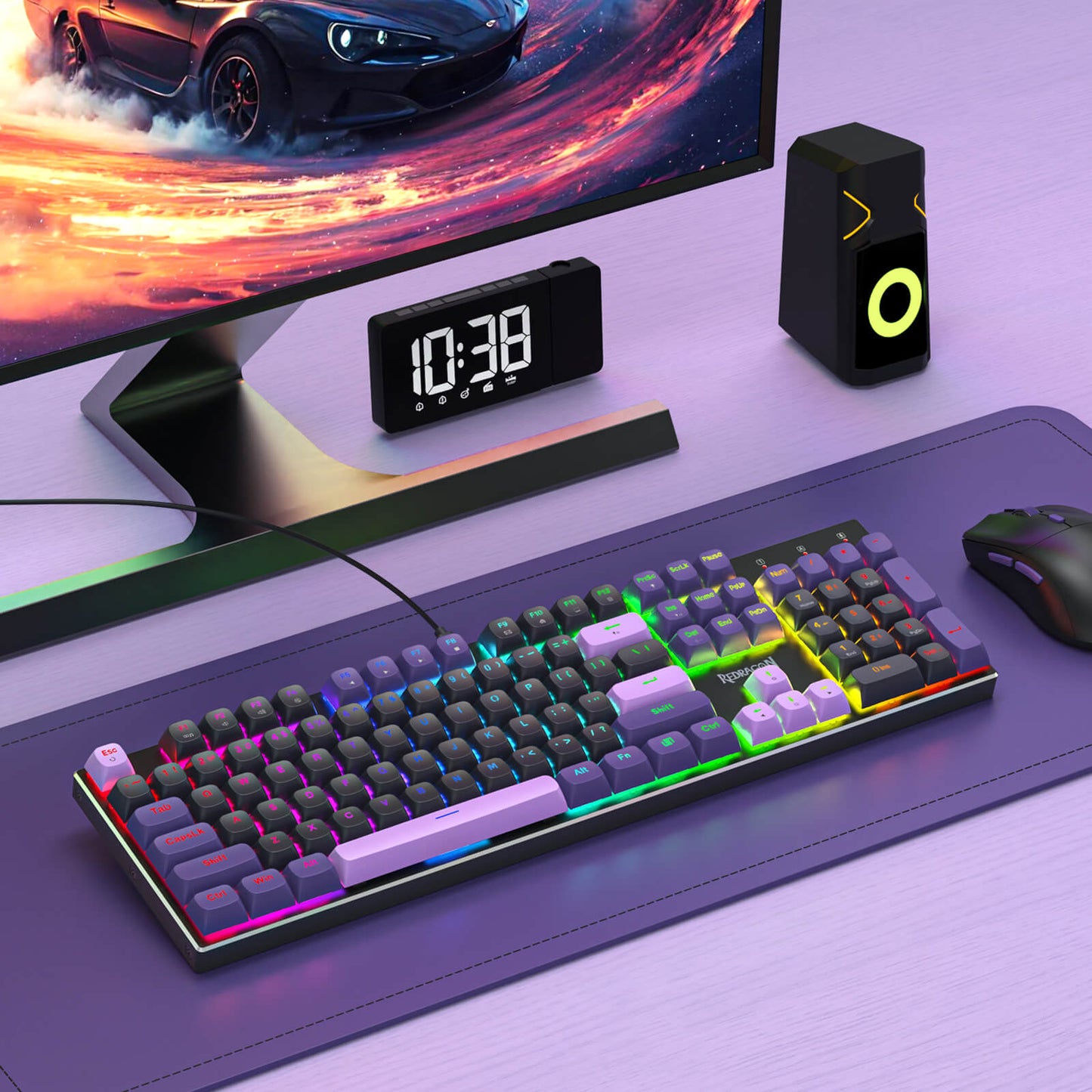 Gaming setup with monitor, keyboard, mouse, and clock on a desk.