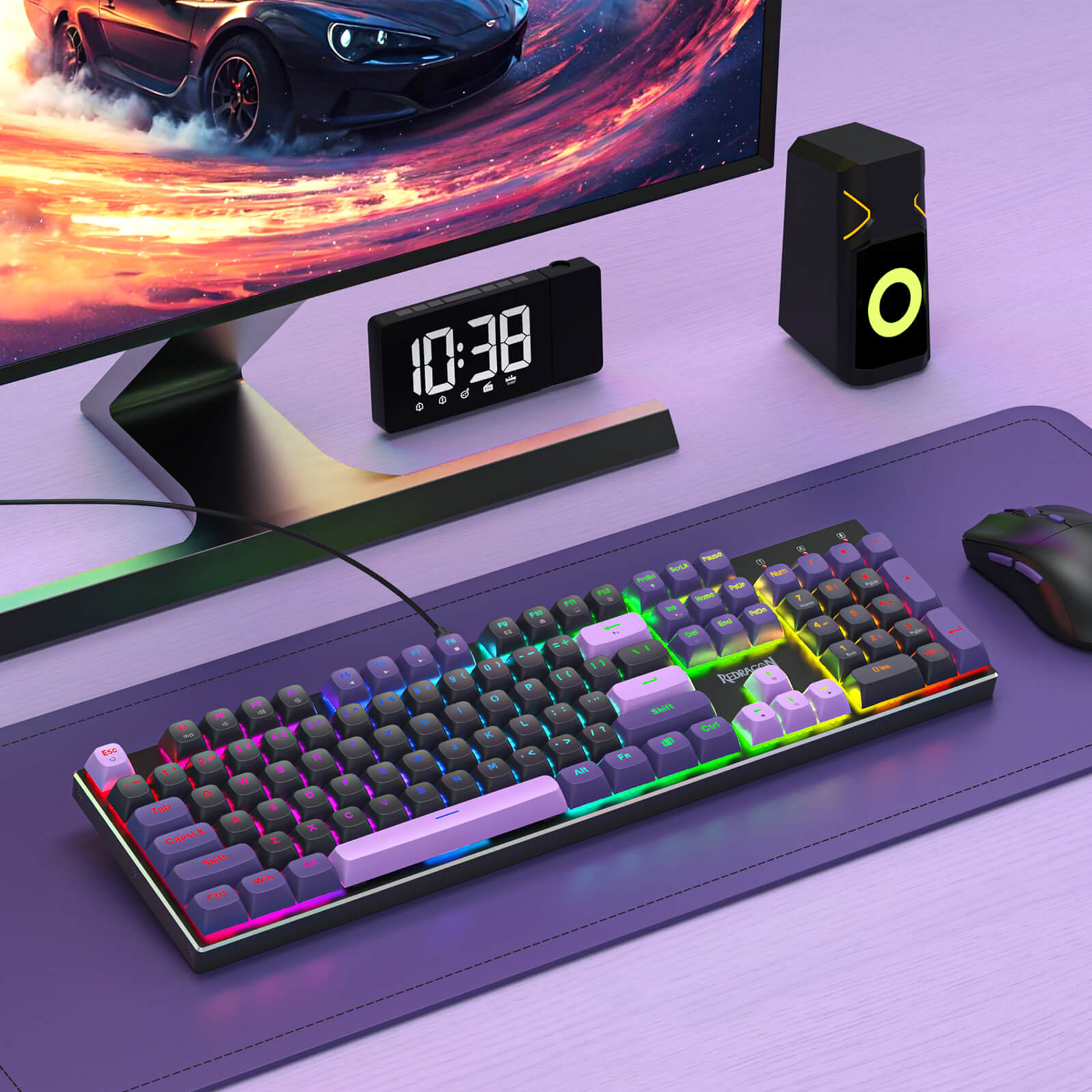 Gaming setup with monitor, keyboard, mouse, and clock on a desk.