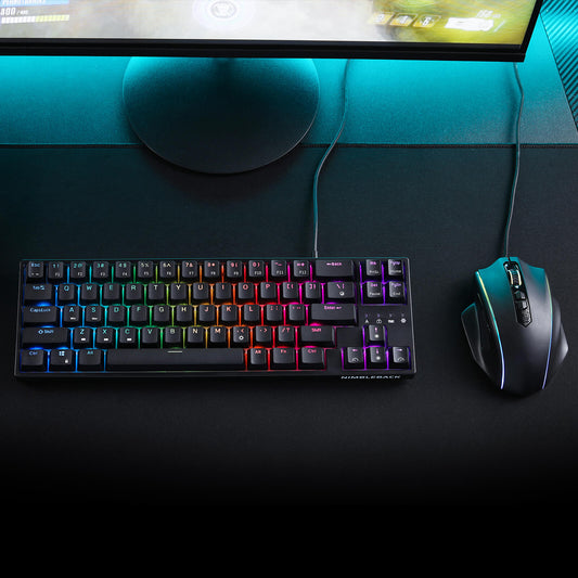 Gaming keyboard and mouse on a desk with a monitor in the background