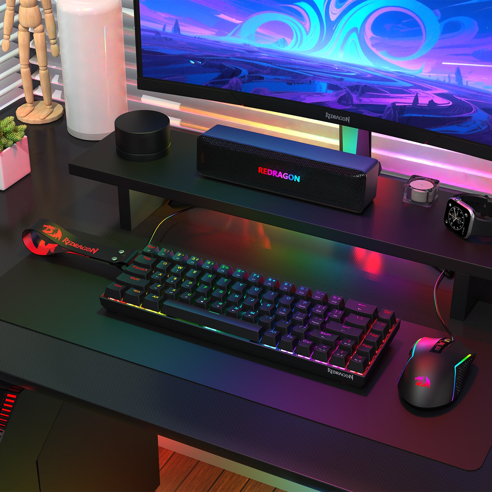 Showcases a Redragon gaming peripheral setup (keyboard, mouse, and speaker) placed on a desk, paired with a monitor