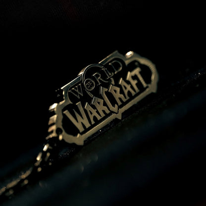 Against a dark, blurred background, a metallic, embossed "WORLD OF WARCRAFT" logo (in a stylized, angular font) catches the light.