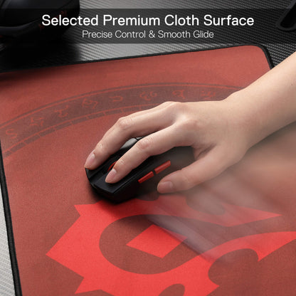 Hand using a mouse on a red gaming mouse pad with text about premium cloth surface.