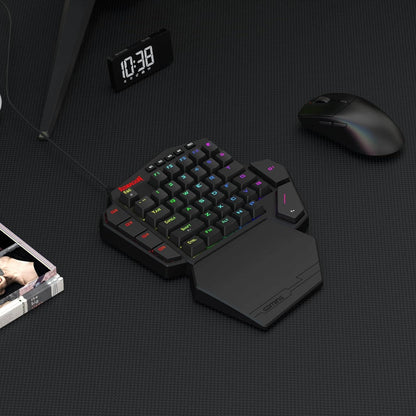 Black ergonomic keyboard with colorful backlighting on a dark surface, next to a mouse and digital clock.