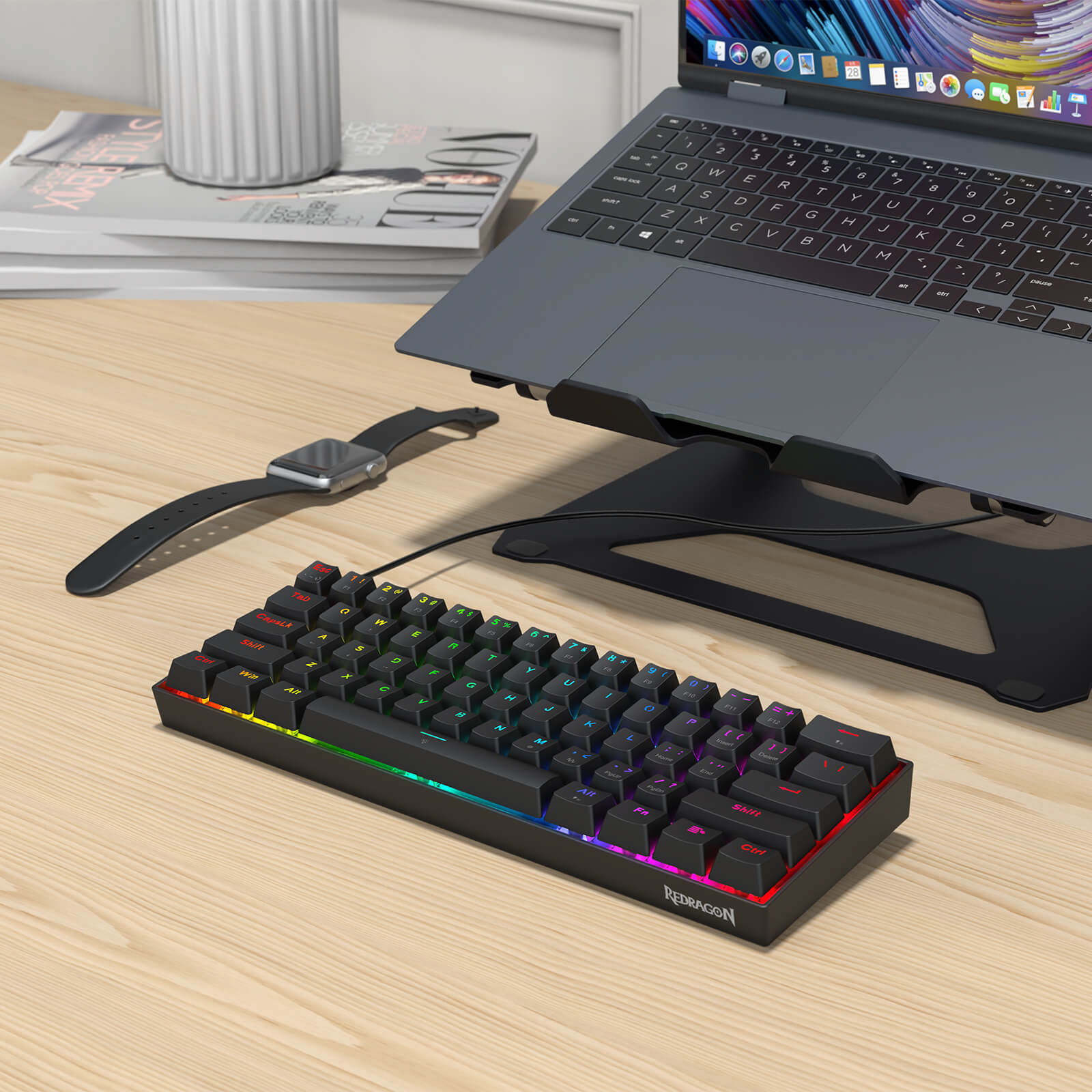 Keyboard with RGB lighting on a desk next to a laptop and smartwatch