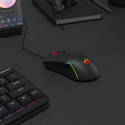 Redragon M730 Gaming mouse and keyboard on a dark surface with smartphone and notebook in the background