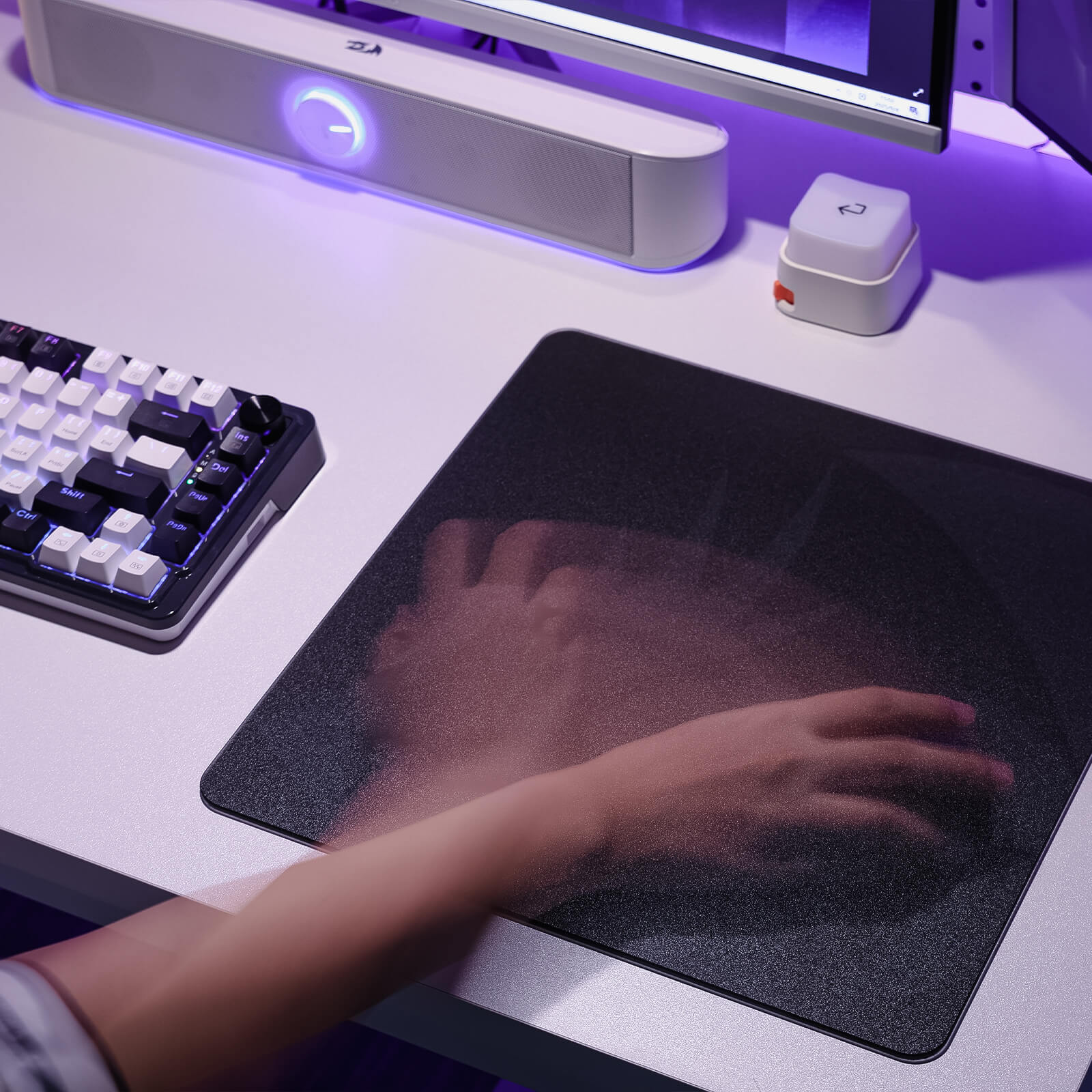 Person using a computer mouse on a desk with a keyboard and monitor in the background.
