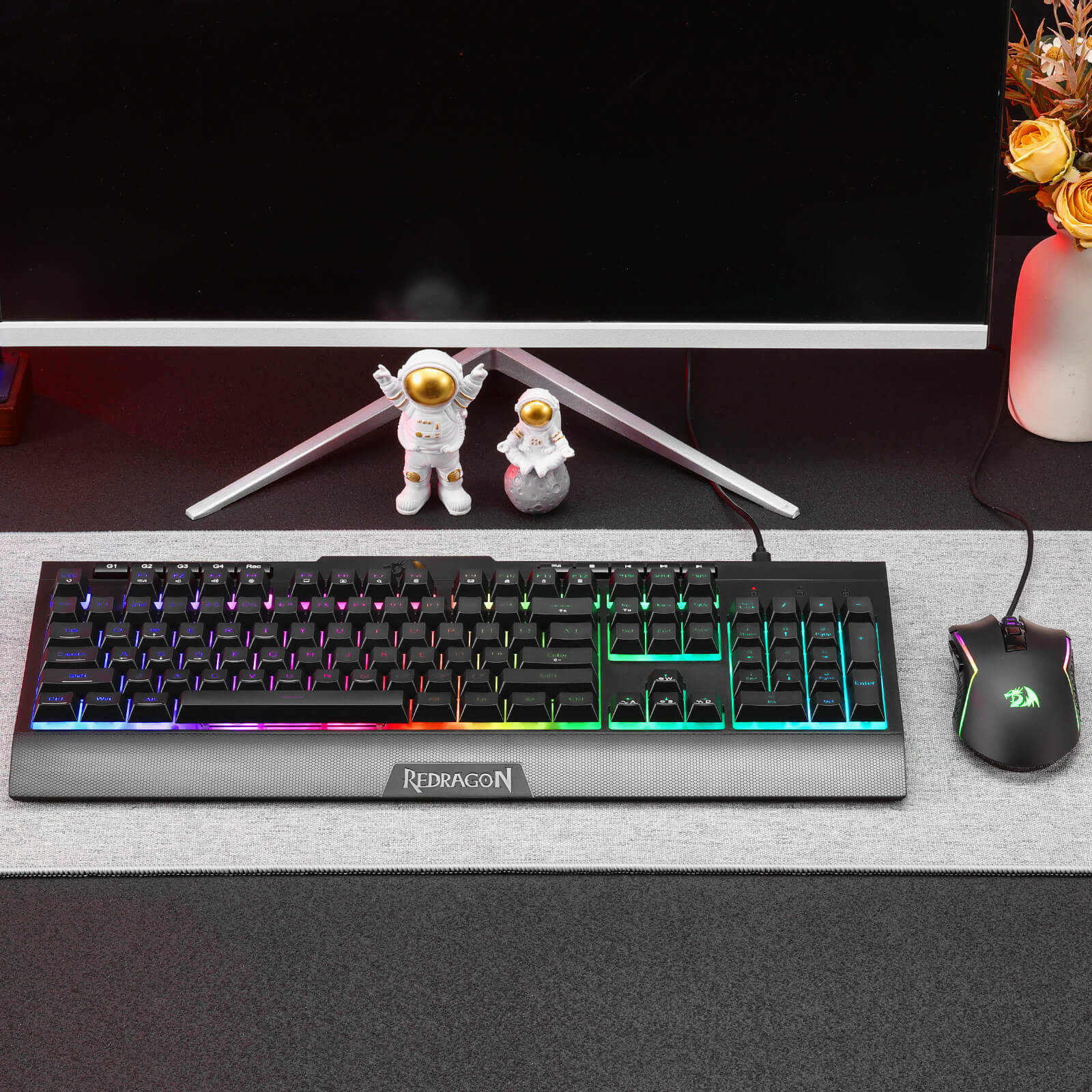 Redragon S151 Gaming keyboard with RGB lighting on a desk with a mouse and decor items.