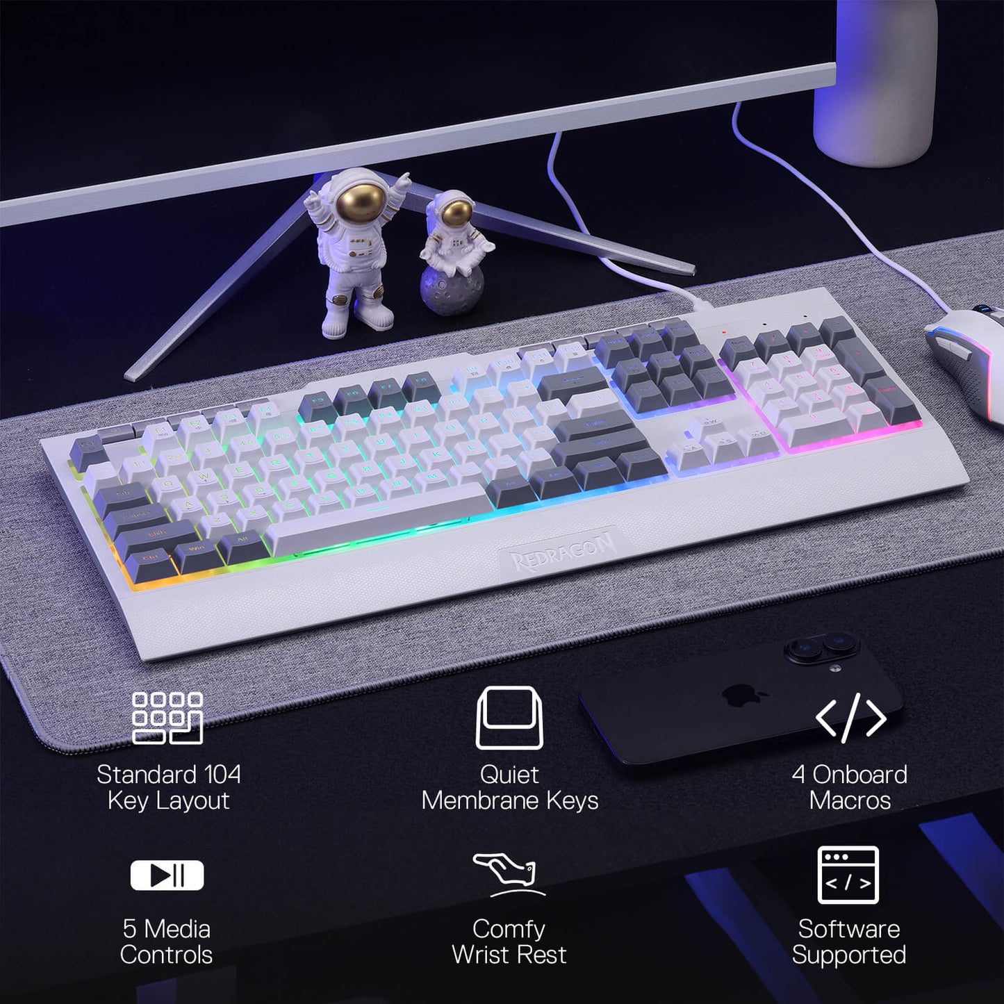 Mechanical keyboard on a desk with astronaut figurines and computer monitor