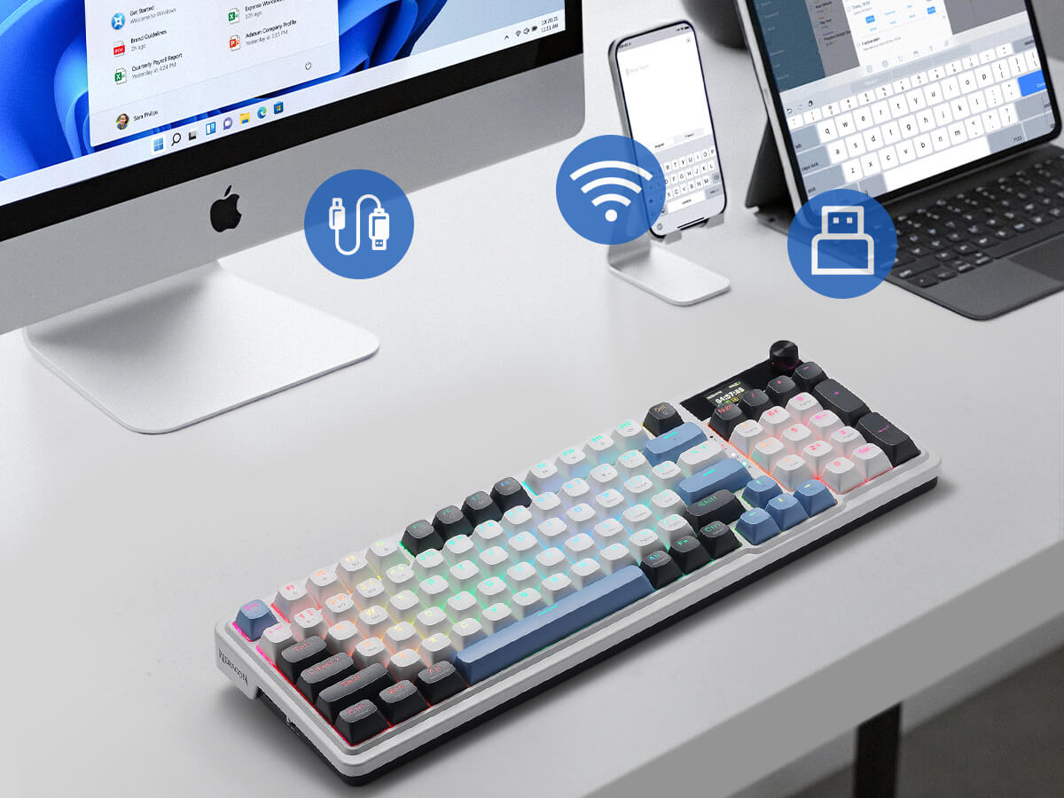 Redragon K719 PRO Mechanical keyboard on a desk with computer monitor, smartphone, and laptop in the background.