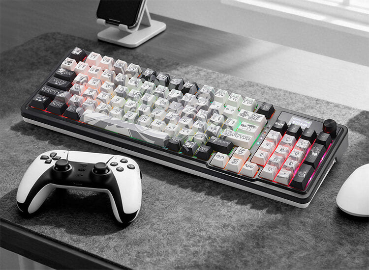 Gaming keyboard with RGB lighting on a desk next to a gaming controller and mouse.