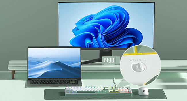 Computer monitor, laptop, keyboard, and clock on a desk with a blue abstract design on the screen.