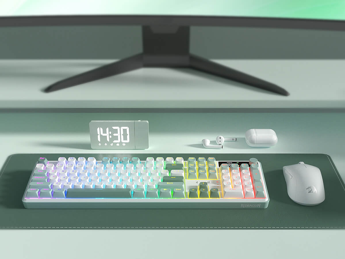 Desk setup with keyboard, mouse, earbuds, and digital clock in front of a computer monitor.