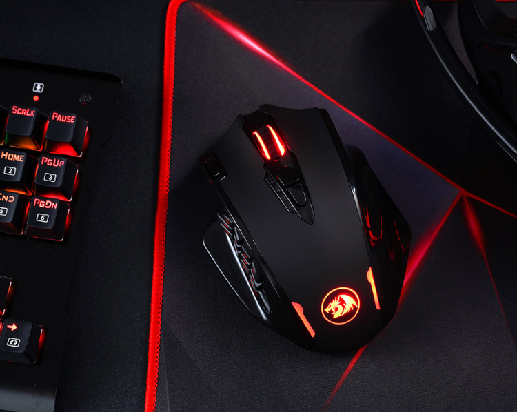 Redragon Gaming mouse with red accents on a dark surface next to a keyboard